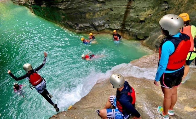 Girl jumping while doing the canyoneering